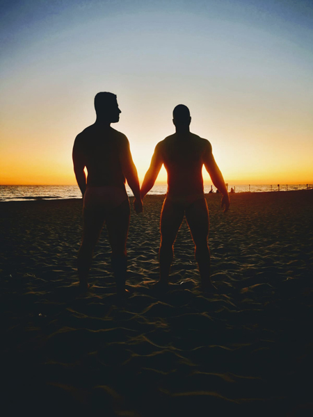 Men holding hands in sunset